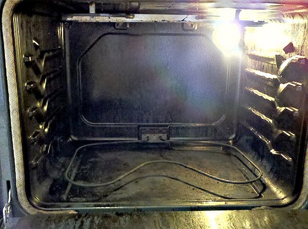 The oven door is open, revealing a spotlessly clean interior thanks to homemade oven cleaner.