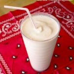 A homemade milkshake with a straw sitting on a red bandanna.