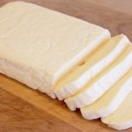 A homemade slice of American cheese on a cutting board.