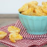 Gluten Free Brazilian Cheese Rolls served alongside cheesy potato chips in a blue bowl on a napkin.