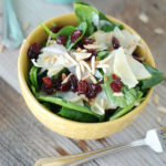 A bowl of craisin salad with almonds.