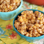 Two bowls of macaroni and cheese topped with ground meat on a table.