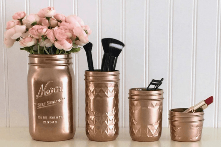 rose gold mason jars holding makeup and makeup brushes and sitting on a counter