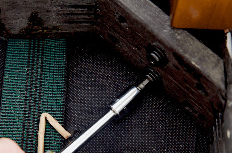 Ways You're Ruining Your Sofa Ways You're Ruining Your Sofa - closeup of tightening a screw underneath a sofa