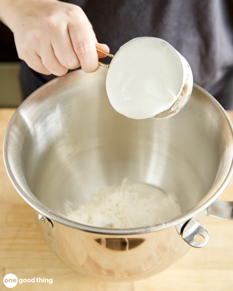 putting greek yogurt into a metal mixing bowl