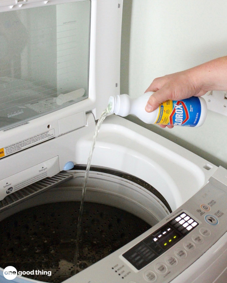 hand pouring Clorox bleach into washing machine