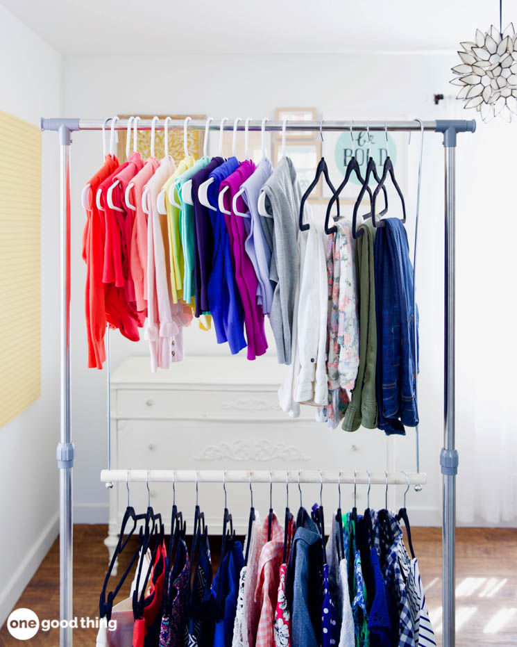 a rainbow of cardigans, slacks, and shirts hanging on a double-bar clothing rack