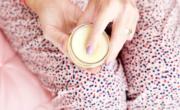         A person holding a jar of sleep salve cream.