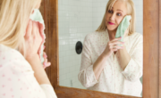 A woman in front of a mirror discovering clever beauty hacks you need.