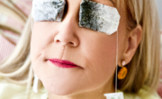 A woman in bed with genius beauty hacks from the beauty edition.