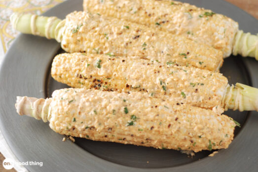 How to Make Elotes (Mexican Street Corn) - four corn on the cob smothered in creamy elote sauce