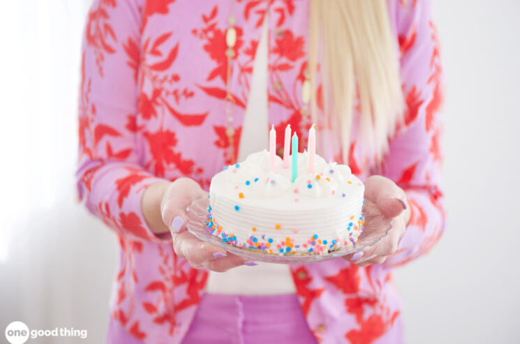 A mom holding a birthday cake.