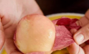 A person effortlessly peeling peaches, demonstrating the simplest method ever.