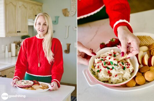 A person in a red sweater presents a platter featuring Miss Mouth's bowl of dip, artfully decorated with red and green sprinkles, surrounded by strawberries, apple slices, and cookies.