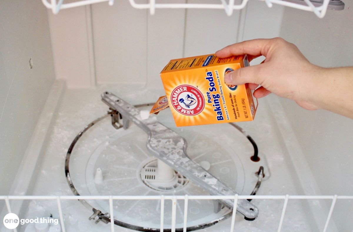 dishwashing hacks_7 A hand pours Arm & Hammer baking soda into an empty dishwasher’s bottom section for dishwashing and cleaning purposes.