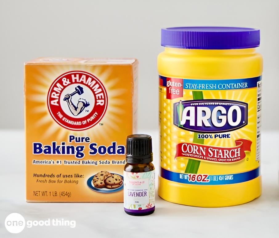 A box of Arm & Hammer baking soda, a bottle of lavender essential oil, and a container—answering what is cornstarch—of Argo corn starch are arranged side by side on a white surface.