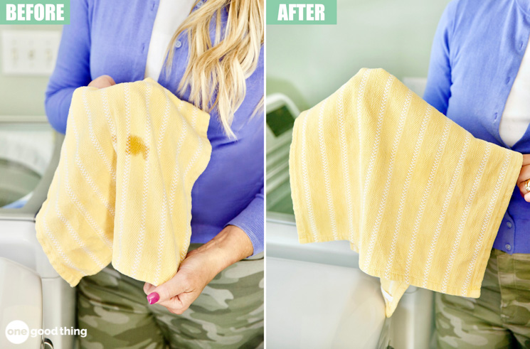 A person holds a yellow striped cloth with a grease stain in the 