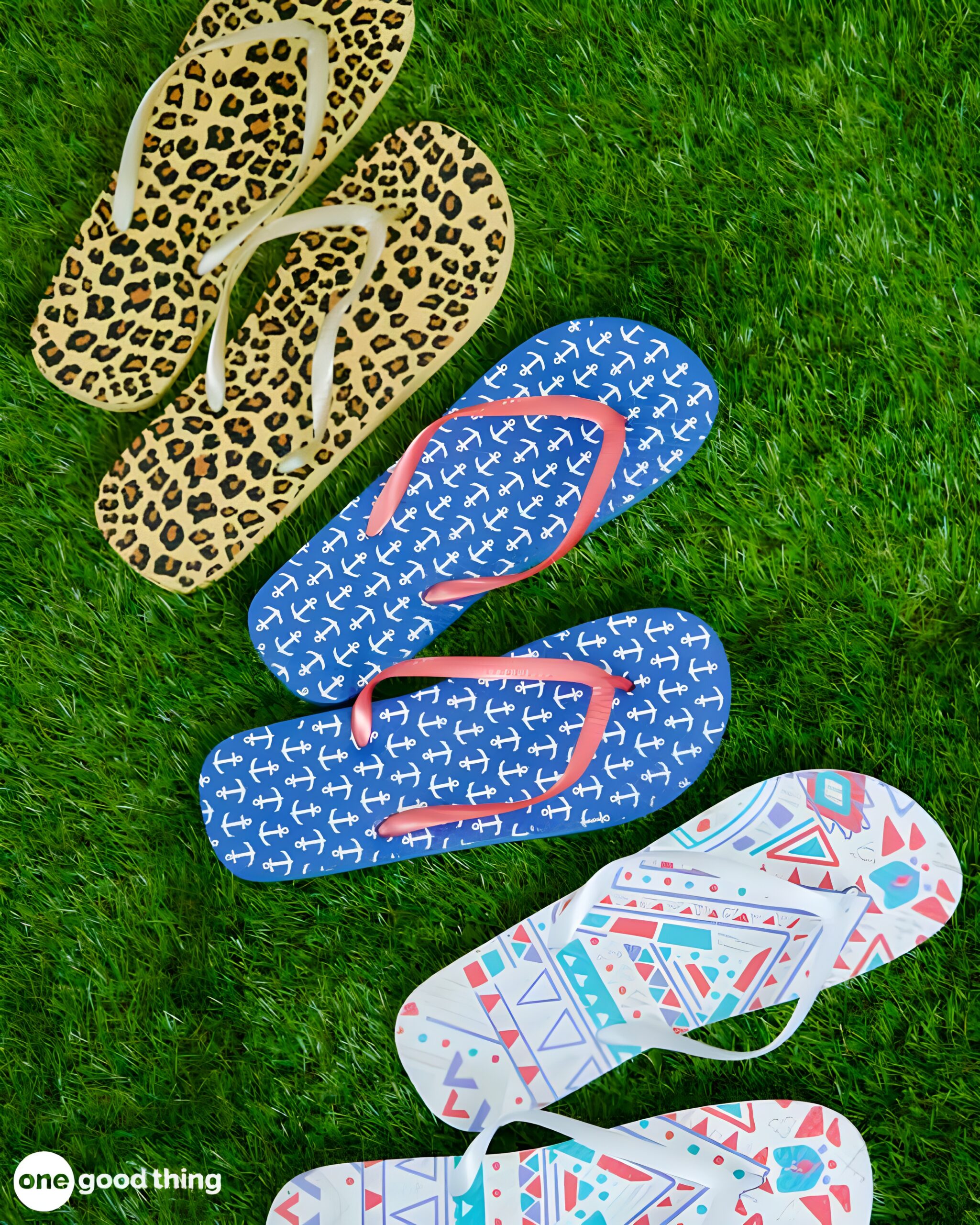 summer-dollar-store6 Three pairs of flip-flops from the dollar store, featuring leopard, anchors, and geometric patterns, are arranged on green grass.