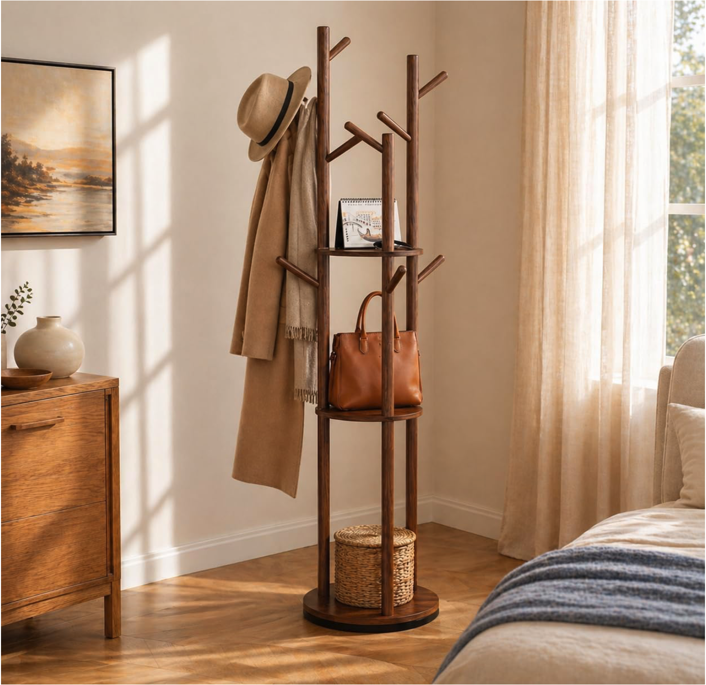 A wooden coat rack with hooks, a small shelf, and a round base, holding a hat, a coat, a handbag, and a basket of misplaced items.